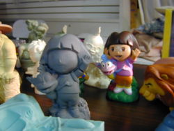 Dora the Explorer sculpture, and the finished painted toy based on it.