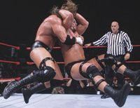 Steve Austin hits the Stone Cold Stunner on Triple H.